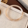 Macro view of amber patterned acrylic resin bangle with vintage marble texture on linen tray - Tea Brown Gradient Thin Style (25722A)