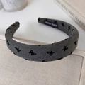 Detail eines grauen gepolsterten Stirnbands mit schwarzen Schleifen und Handmade-Label - Grau Schleife