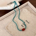 Detail van de rode agaatkraal op blauwe kristallen ketting met zilveren sluiting - Blauwe Kralenstijl