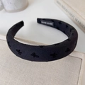 Nahaufnahme des dicken schwarzen Haarreifens mit bestickter Schleife und Label-Detail - Schwarze Serie Schleifen