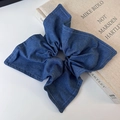 Dettaglio dell'elastico in denim blu scuro con cuciture bianche su un libro beige - Stile Quadrato (25744B) / Blu Denim Lavato