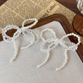 Detalle de lazos para zapatos con perlas y cuentas facetadas sobre fondo de estilo retro - Lazo de Doble Capa Blanco (25717B)