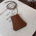 Close-up of a brown leather bell clochette key case with white stitching details - Brown