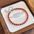 Macro-opname van rode agaat kralenarmband met blauwe spacers en zilveren sluiting - Rood Blauw Kralenmix Armband