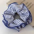 Detailed view of striped blue and white fabric scrunchie with neat overlock wave edges - White Striped