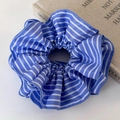Macro shot of blue and white striped fabric scrunchie with fine stitching details - Light Blue Striped