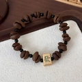 Close-up of coffee bean beads bracelet with a golden Mahjong charm showing Fa character - Mahjong Fortune Style (25776B)