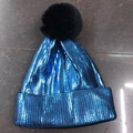 Detail of blue sequined winter knit beanie featuring a large black faux fur pom-pom topper - Adult / Lake Blue