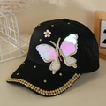 Detalle de gorra negra con mariposa de lentejuelas, perlas y pedrería dorada fina - Negro
