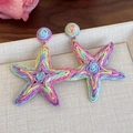 Handcrafted star-shaped woven raffia earrings in vibrant macallon colors for travel - Starfish Style