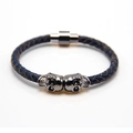 Close-up of navy blue braided leather bracelet with silver metal skulls and magnetic clasp - Gun Black and Blue