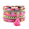 Detailansicht eines Boho-Armbands mit rotem Stoff, Strasssteinen und rosa Baumwollquaste - Rosa