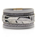 Dettaglio di un bracciale multistrato in pelle grigia boho con piuma d'argento e strass - Grigio