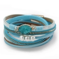 Detail eines mehrlagigen Wickelarmbands mit Türkisstein, Perlen und Goldkettenelementen - Himmelblau