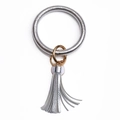Détail du porte-clés bracelet en similicuir argenté avec pompon à franges et anneau d'or - Argenté