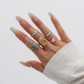 Silver-toned acrylic ring set featuring yellow, gray, and pink stones on a model's hand - Silver Tone Ring Set Four