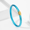 Detalle de pulsera de silicona esmaltada azul brillante con placa decorativa grabada en oro - Azul lago