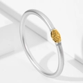 Detalle del brazalete de plata mate con pieza central ovalada dorada y relieve - Plateado