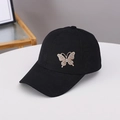 Dettaglio della decorazione a farfalla con strass dorati su cappello nero jacquard - Taglia unica / Nero