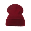 Close-up of dark red ribbed knit texture and folded cuff on a warm winter beanie hat - Adult / Burgundy