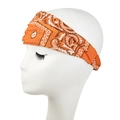 Detailed view of an orange paisley headband on a white mannequin head for sport and yoga - Gold Yellow
