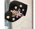 Détail de fleurs en tissu coloré et perles sur un chapeau de soleil en tricot noir chic - Taille unique / Noir