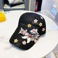 Dettaglio del cappellino a rete con ricami floreali 3D colorati e texture intrecciata - Nero / Taglia unica