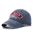 Detailed view of red BOSTON embroidery and distressed brim on washed denim baseball cap - One Size / Navy Blue