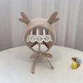 Cute beige knitted baby bonnet with reindeer antlers and chin straps on a display stand - 40-48cm / Beige