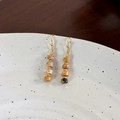 Macro detail of vintage tiger eye stone beaded earrings with golden hooks on ceramic tray - Earth Tone Tiger Eye Style (24356A)