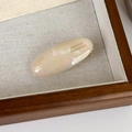 Macro detail of pearlescent white oval hair clip with France Handmade text on silk - Iridescent Rice Color
