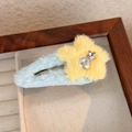 Dettaglio molletta a stella in peluche con strass colorati e ciondolo in argento su pelliccia - Base Blu Stella Gialla
