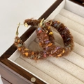 Close-up of brown plush hoop earrings with colorful specks in a wooden jewelry box - Brown Multi