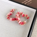 Detalle de pendientes de corazón de felpa a rayas rosas y marrones con textura invernal - Corazón Rojo Café