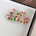 Primer plano de aretes grandes de corazón de peluche con texturas festivas de tres colores - Corazón Rosa Verde