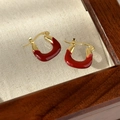 Detail of red enamel U-shaped hoop earrings with gold plating on textured linen fabric - French U-Shape Style (12# 24330D)