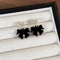 Detalle de pendientes de lazo de terciopelo con corazones de pedrería en joyero de regalo - Negro