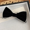Close-up of black velvet bow hair clip with sparkling rhinestone edges and fine texture - Black Bow