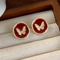 Detailed macro of red enamel butterfly stud earrings inside a beige jewelry gift box - Gold Butterfly on Red Style (18# 26303)