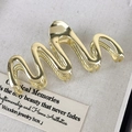 Primo piano di un fermaglio per capelli dorato lucido con design a onde metalliche - Oro
