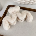 Macro detail of wave-shaped plush hair claw clip in creamy white faux fur material - Beige