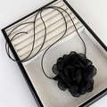 Détail du ras-du-cou camélia 3D en tissu noir avec pétales en mousseline et cordon ciré - Fleur noire