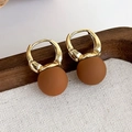 Dettaglio di orecchini con perline marroni opache e fibbia in metallo dorato su legno - Orecchini Minimalisti con Sfera Opaca (22177B)