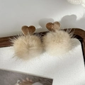Nahaufnahme flauschiger beiger Pelzohrringe mit braunem Cordherz-Detail auf dem Tablett - Milchtee-Farbe