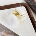 Dettaglio della molletta dorata con pompon in pelliccia bianca su vassoio di legno - Bianco (Base Oro 24563A)