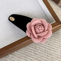 Detail einer rosa Samt-Kamelie-Haarklammer mit Goldverzierung auf einem Tablett - Schwarzer Wassertropfen BB-Clip