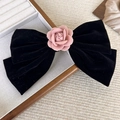 Detail of elegant black velvet hair clip featuring a pink camellia flower texture - Black Bow Spring Clip