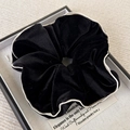 Gros plan d'un chouchou en velours noir avec liseré blanc dans un coffret cadeau - 8cm / Noir