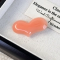 Dettaglio di un fermaglio per capelli a cuore color pesca su tessuto bianco elegante - Rosa Pesca