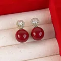 Orecchini vintage dorati con pendenti in perla rossa e zirconi su velluto bianco - Rosso